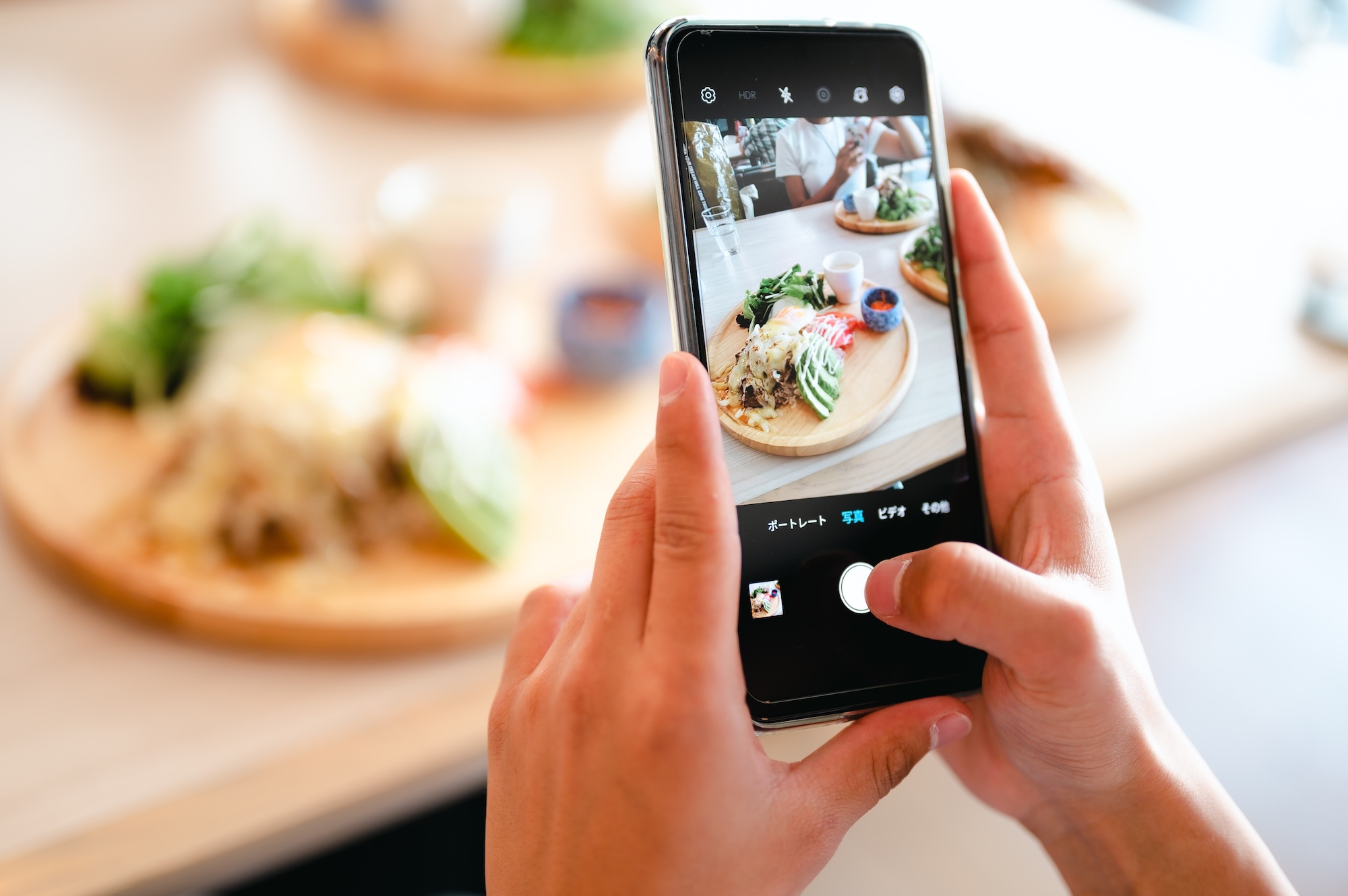 スマートフォンで料理を撮影する様子